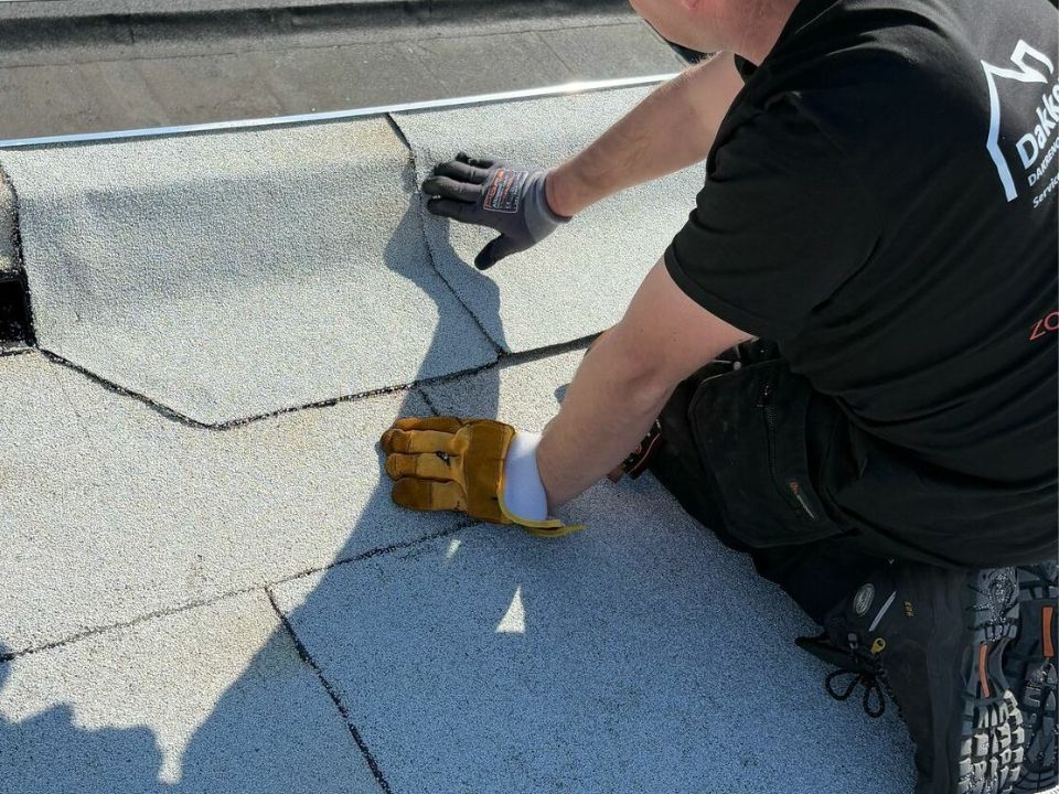 Dakdekker inspecteert de oorzaak van een daklekkage